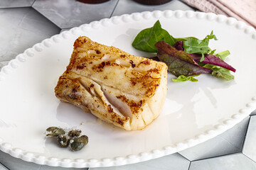 Roasted cod fish steak with salad