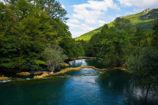 Travertine pools in the River Una as it flows away from the Small Waterfalls at Martin Brod in Una-Sana Canton, Federation of Bosnia and Herzegovina. Located within the Una National Park. Early Septem