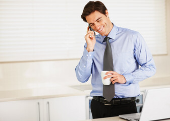 Happy businessman, phone call and laptop with coffee for discussion or communication in kitchen at home. Man or employee talking on mobile smartphone for morning conversation with cup of tea at house