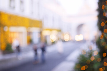 A blurred background of a street decorated for the New Year. A place to advertise. Happy New Year. Silhouettes of people are out of focus.