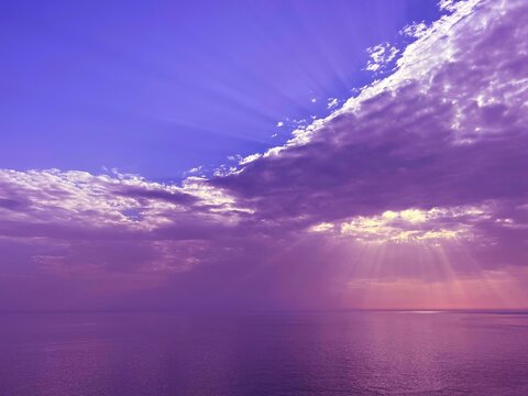 Sunset sun rays over sea water.