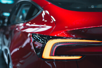 Close-up of a modern red crossover automobile with LED red taillights. The rear window of a red car...