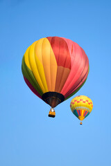 Colorful balloon over blue sky in the bright sun light.