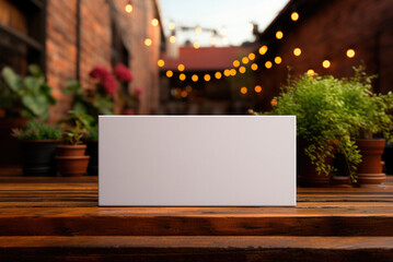 Mockup business card on a wooden table against the background of a outdoor cafe