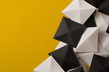 Black and white geometric 3d shapes on yellow background, copy space