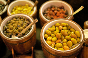 Assorted olives in a rustic market setup. Captures the essence of traditional culinary practices in modern commerce.