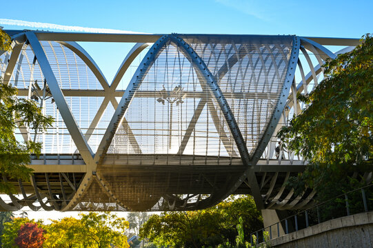 MADRID, SPAIN - November 17, 2023: Arganzuela Bridge in Madrid Rio Park, Designed by Dominique Perrault, it is 274 meters in length and formed by two spiral-shaped walkways . High quality photo
