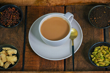Fresh milk masala tea or Indian Kadak Chai.  Herbal tea in glass cups. Locally called mini cutting chai or cutting chai or masala chai. Indian chai in glass cups and other masalas to make the tea