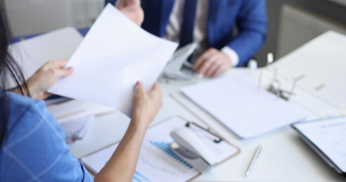 Man and woman sorting documents with stapler and hole punch and folding into folders 4k movie slow motion. Archiving documents concept