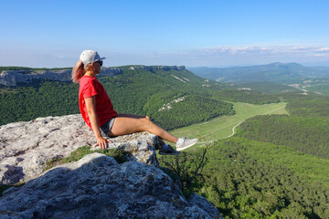 Mangup-Kale cave city, sunny day. A girl on the background of a mountain view from the ancient cave city of Mangup-Kale in the Republic of Crimea, Russia. Bakhchisarai.