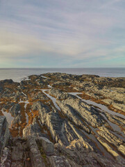 The rocky coast of the Barents Sea. Beautiful view of the rocks and the coast of the Rybachy and Sredny peninsulas, Murmansk region, Russia. The landscape is the harsh beauty of the north.