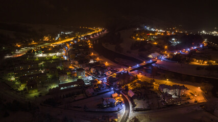 Fototapeta na wymiar Lot nad Muszyną nocą w zimie. Zimowy, nocny krajobraz.