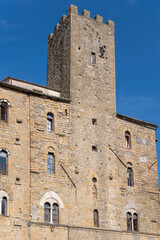 tower house and stone facade at Priori square, Volterra, Italy