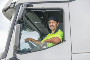Smiling male driver looking through window of truck