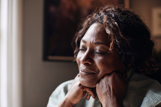 Mature Woman With Eyes Closed Day Dreaming At Home