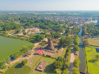 Aerial view of Sukhothai Historical Park, buddha pagoda stupa in a temple, Sukhothai, Thailand with green mountain hills and forest trees. Thai buddhist temple architecture. Tourist attraction.
