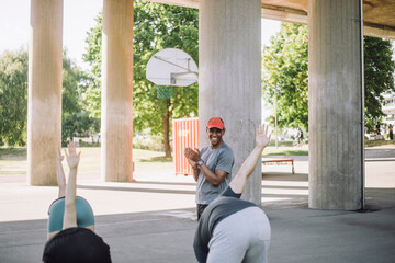 Smiling male coach motivating team during training session