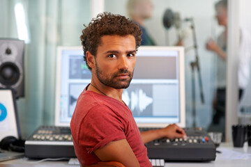 Portrait, music and a man producer in a recording studio mixing audio with a sound desk. Computer,...