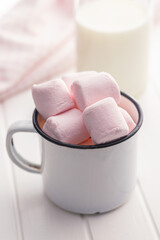 Sweet marshmallows candy in cup on kitchen table.
