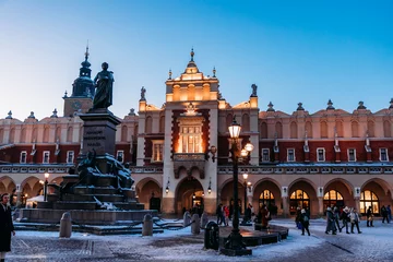 Rolgordijnen Krakow Christmas Market Square - before the sunset. Beautiful Sukiennice (Cloth Hall) and Adam Mickiewicz sculpture © katarzynapracuch