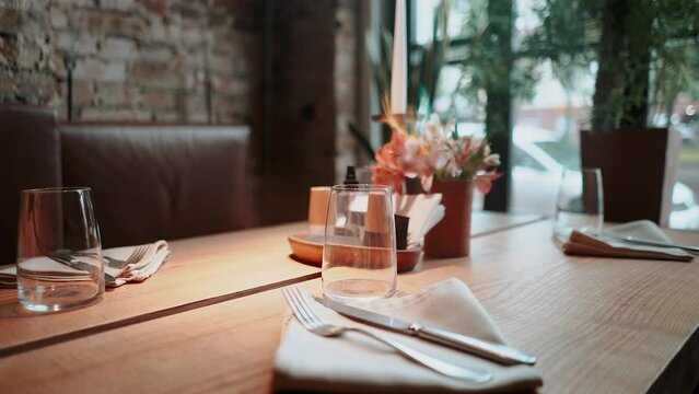 table setting with napkin, fork, knife, tablecloth and flowers in an expensive luxury restaurant, Georgian atmosphere loft interior