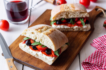 Ciabatta with cheese, tomatoes, sausage, olives and arugula. Sandwich. Italian food.