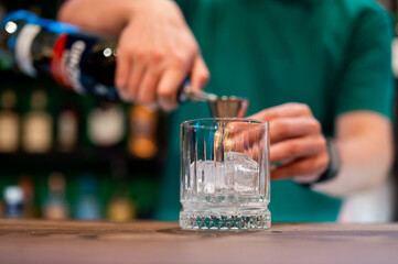 Ice cube in an empty glass on a bar counter in bar or pub
