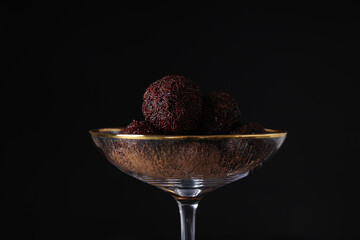 Brigadeiro in cocktail glass on black background, close up
