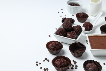 Brigadeiro and chocolate in bowls on white background, space for text
