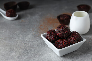 Brigadeiro in bowl on gray background, space for text