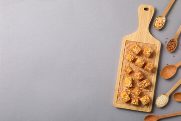 Fried tofu on a wooden board with spoons