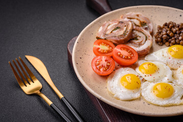 Delicious nutritious breakfast of fried quail eggs, bacon, legumes and cherry tomatoes