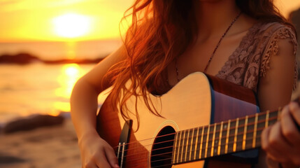 Beautiful romantic curly woman, with a guitar, sitting on the beach at sunset. Space for text