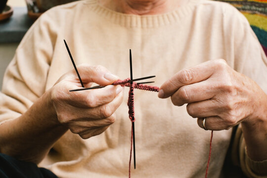 Midsection of senior woman knitting while sitting at home