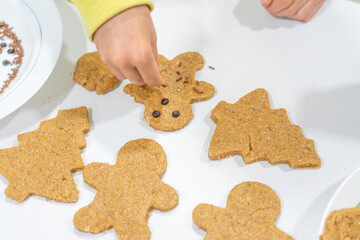 Child's hands decorating some homemade Christmas cookies