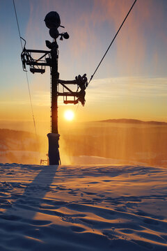 Ski lift at sunset with sun