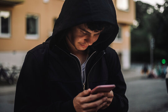 Teenage boy text messaging through smart phone