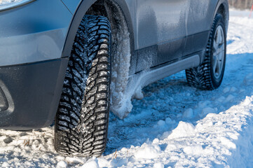 close up of studded tires on car standing on snow