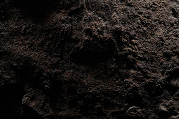 Brown stone texture, dark abstract background. Natural mineral rock close up details, empty backdrop with copy space for design