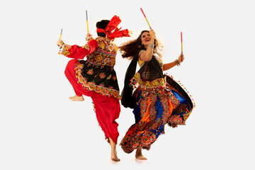Portrait of happy young couple performing Dandiya Raas during Navratri celebration - obrazy, fototapety, plakaty