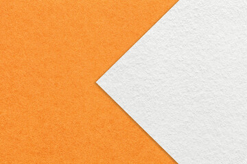 Texture of orange paper background, half two colors with white arrow, macro. Structure of craft cardboard.