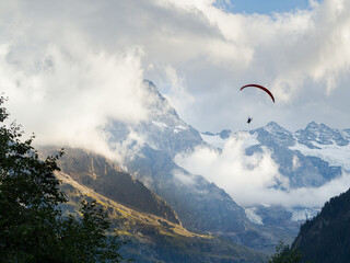 Paragliding with mountains and glaciers background in Swiss Alps