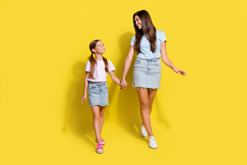 Photo of two girls enjoy free time together older sister hold hand younger isolated over bright color background