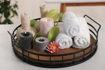 Composition with different spa products and burning candles on white table