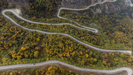 the road running serpentines in the autumn mountains