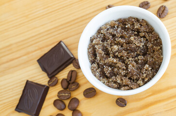 Homemade exfoliating foot and body aroma scrub with ground coffee, sugar, chocolate and olive oil. Natural beauty treatment and spa recipe. Top view, close up.