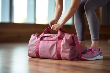Papier Peint photo Lavable Fitness Cropped shot of fit sporty woman in sportswear with gym bag wearing toned yoga pants and sneakers getting ready for exercise session at gym.