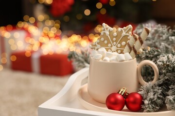 Delicious cocoa with marshmallows, wafer sticks and gingerbread cookie with Christmas decorations on white tray, space for text