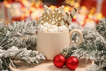 Delicious cocoa with marshmallows, wafer sticks and gingerbread cookie with Christmas decorations against blurred background, closeup
