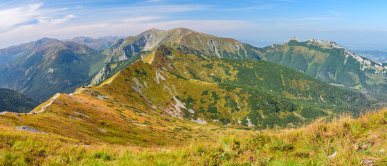 Fototapeta na wymiar Polish Tatra Mountains, high mountain hiking trail leading to mountain peaks, mountain landscape with valleys and slopes, view on a sunny summer day.